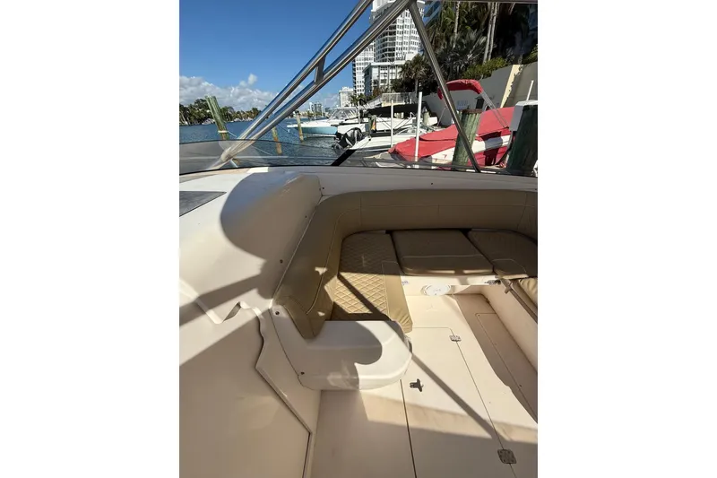 Slide: The Image of 2008 Intrepid 370 Cuddy boat interior with seating, docked by waterfront buildings. - 31