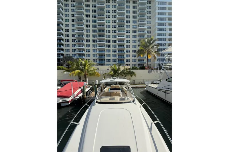 Slide: The Image of 2008 Intrepid 370 Cuddy boat docked near waterfront apartments and palm trees. - 42