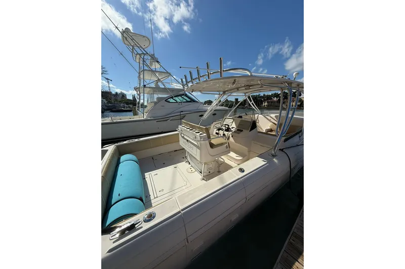 Slide: The Image of 2008 Intrepid 370 Cuddy boat with open cockpit and helm, docked under blue sky. - 5