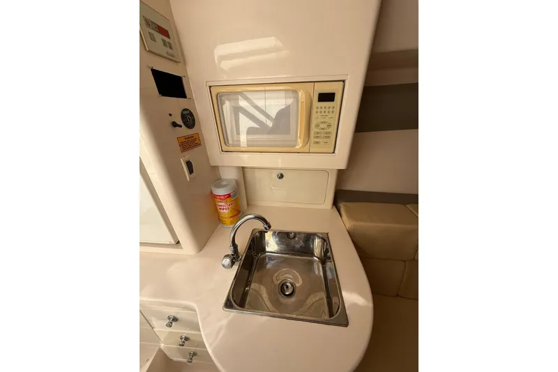 Slide: The Image of 2008 Intrepid 370 Cuddy interior with microwave, sink, and disinfectant wipes. - 58