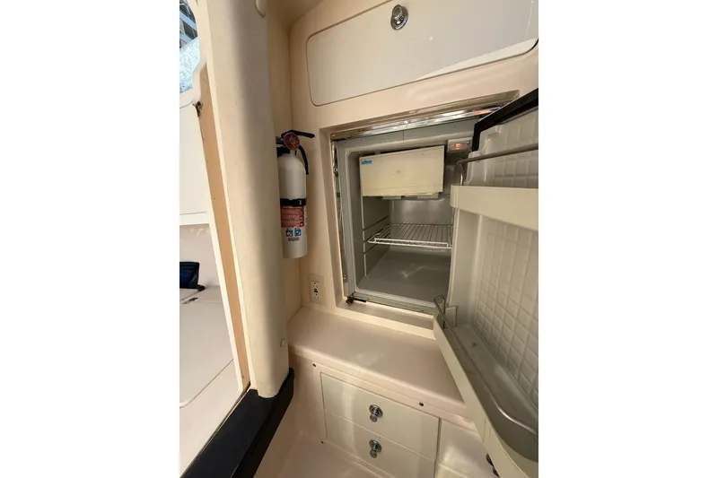 Slide: The Image of 2008 Intrepid 370 Cuddy interior with open refrigerator and fire extinguisher. - 60