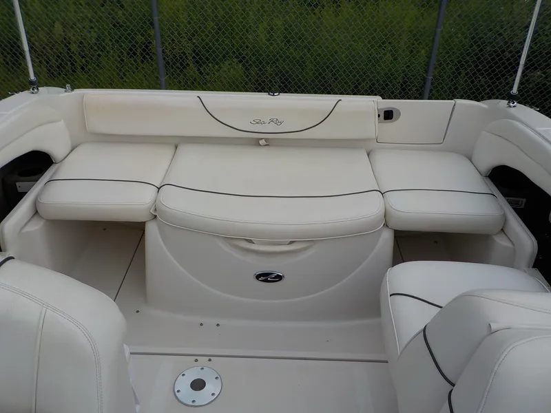 Slide: The Image of The 2004 Sea Ray 225 Weekender features a spacious, cushioned seating area in cream leather. - 14