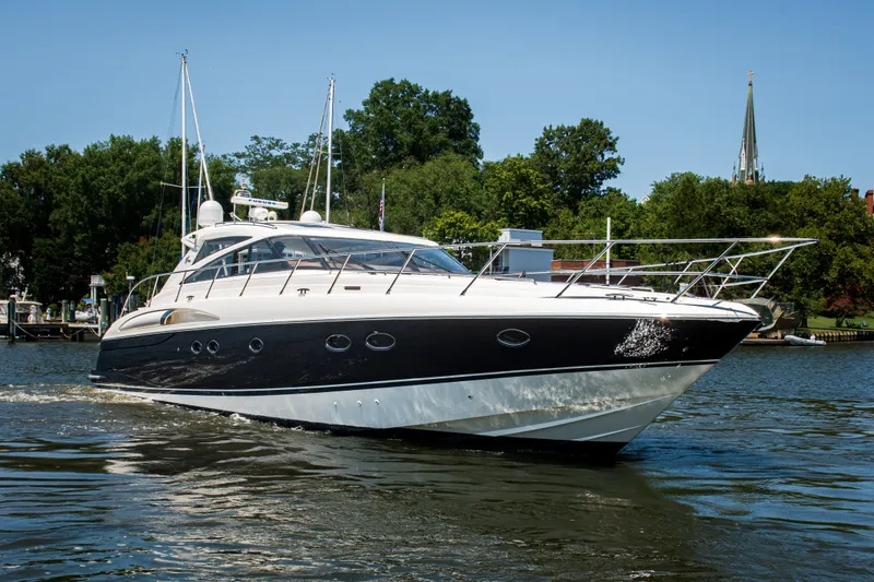 The Image of 2008 Princess V58 yacht cruising on a scenic waterway with lush greenery. - 0