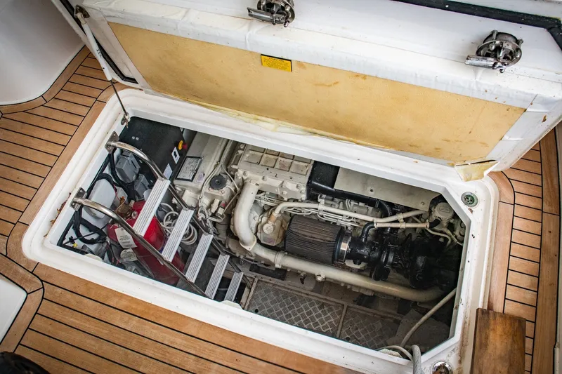 Slide: The Image of Engine compartment of a 2008 Princess V58 yacht, showcasing mechanical components and wooden deck. - 19