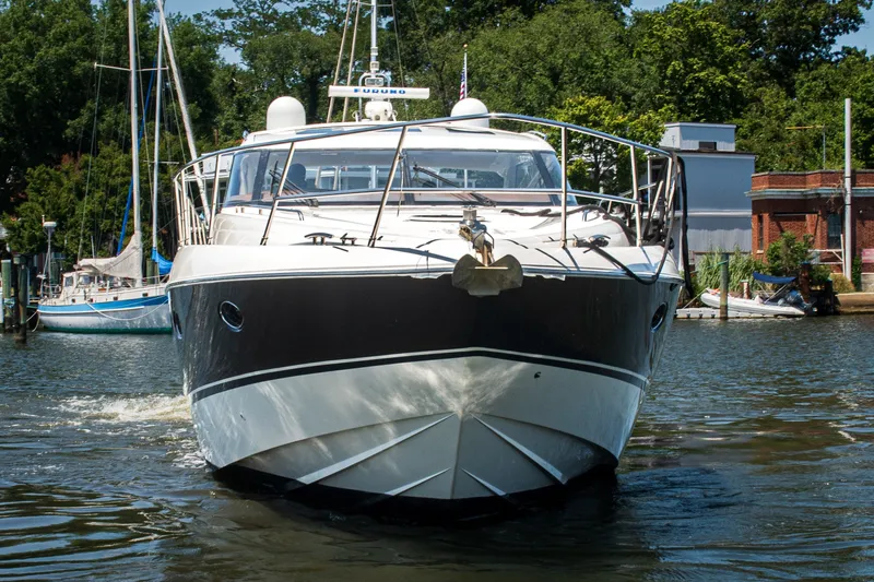 Slide: The Image of 2008 Princess V58 yacht cruising in a marina, surrounded by trees and buildings. - 4