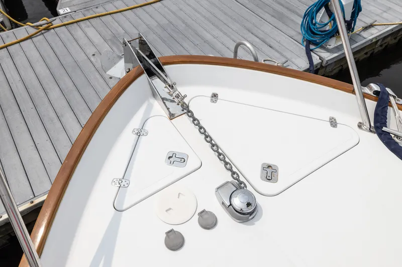 Slide: The Image of Bow of 2007 Legacy 32 Express boat docked, featuring anchor chain and deck fittings. - 14