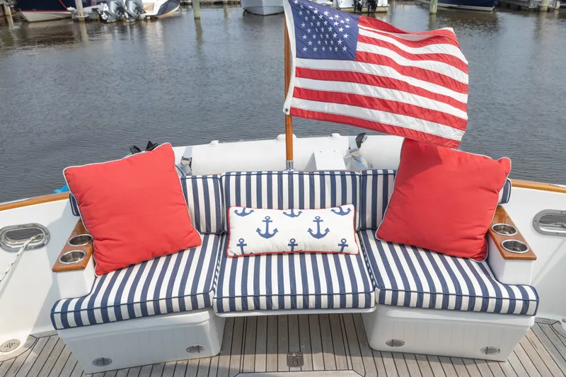 Slide: The Image of Cozy seating on 2007 Legacy 32 Express boat with American flag and nautical cushions. - 2