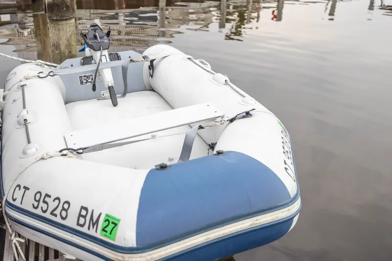Slide: The Image of Inflatable boat docked on calm water, featuring registration number CT 9528 BM. - 18