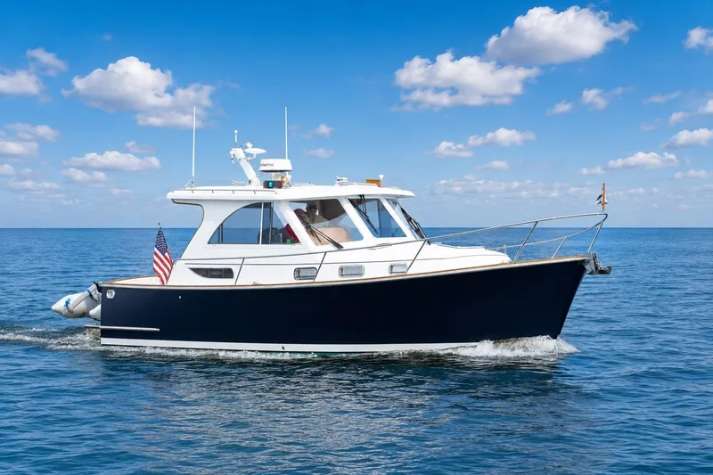 The Image of 2007 Legacy 32 Express boat cruising on open water under a clear blue sky. - 0