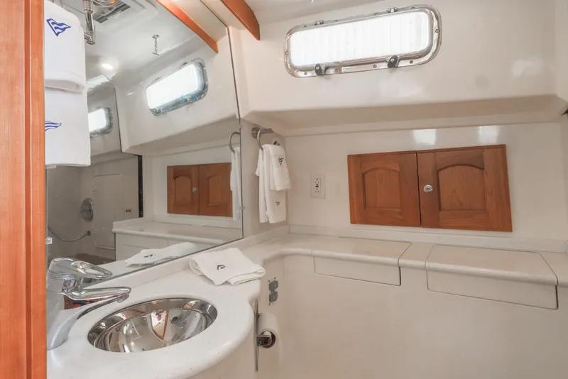 Slide: The Image of 2007 Legacy 32 Express yacht bathroom with sink, mirror, and wooden cabinets. - 8