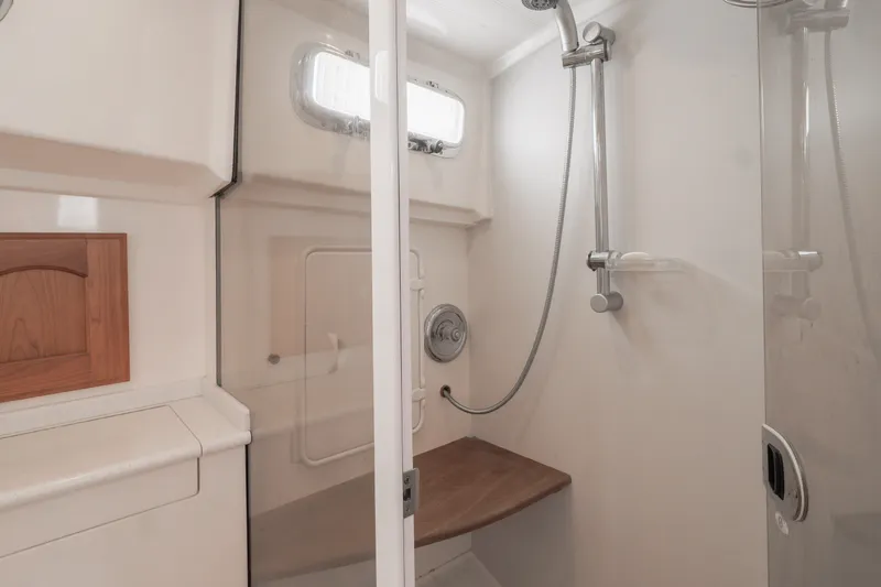 Slide: The Image of Shower area in 2007 Legacy 32 Express boat, featuring modern fixtures and wooden accents. - 9