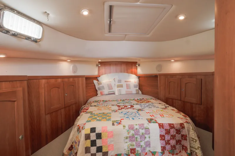 Slide: The Image of Cozy cabin interior of 2007 Legacy 32 Express with quilted bedspread and wooden cabinetry. - 7