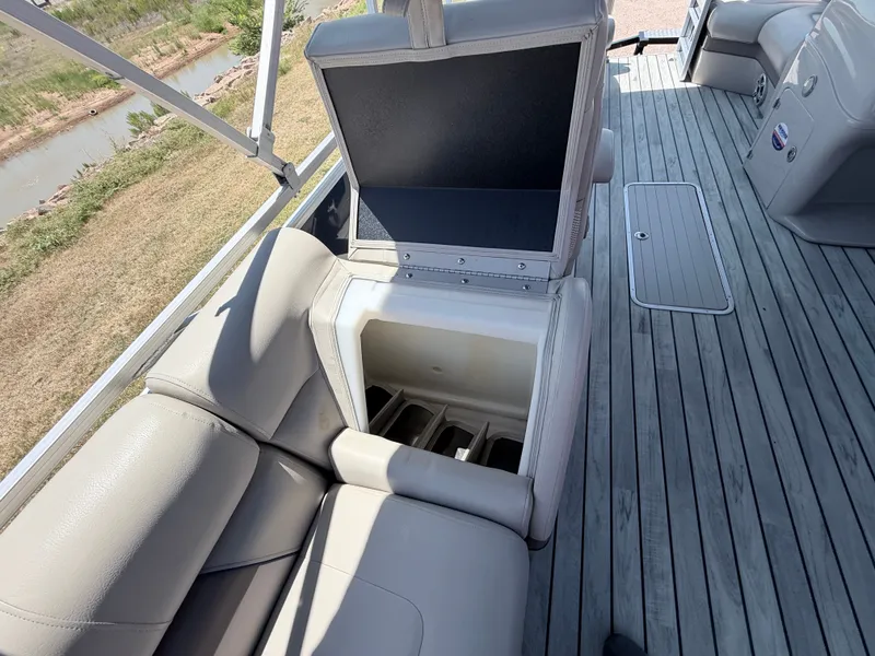 Slide: The Image of A 2018 Trifecta pontoon boat with gray leather seats and storage space under the seat. - 17