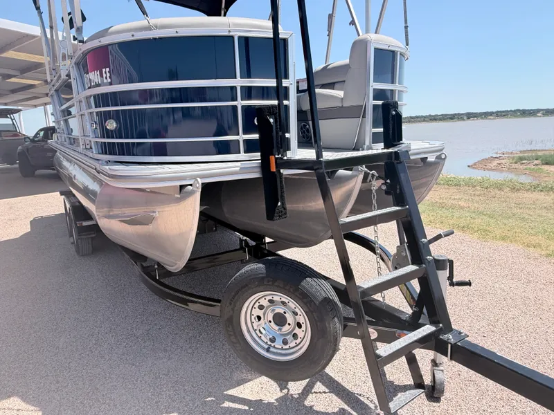 Slide: The Image of A 2018 Trifecta pontoon boat on a trailer, featuring a blue hull and silver details. - 3