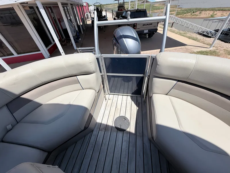 Slide: The Image of The image shows the deck of a 2018 Trifecta pontoon boat with beige seating. - 19