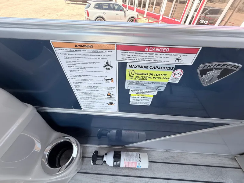 Slide: The Image of A 2018 Trifecta boat with warning labels and capacity information on the side. - 23