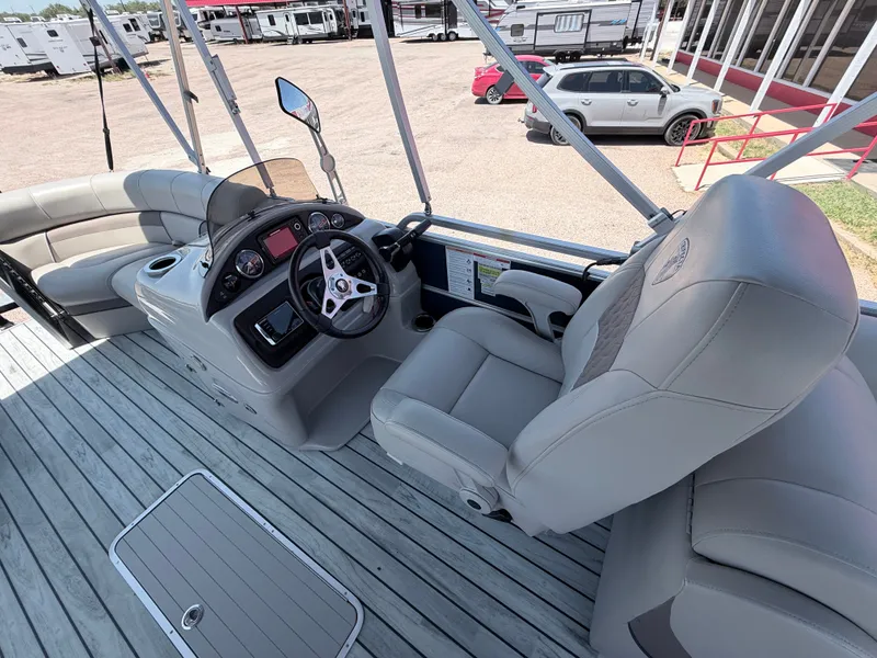 Slide: The Image of The image shows the cockpit of a 2018 Trifecta pontoon boat with gray leather seats and a modern helm. - 12