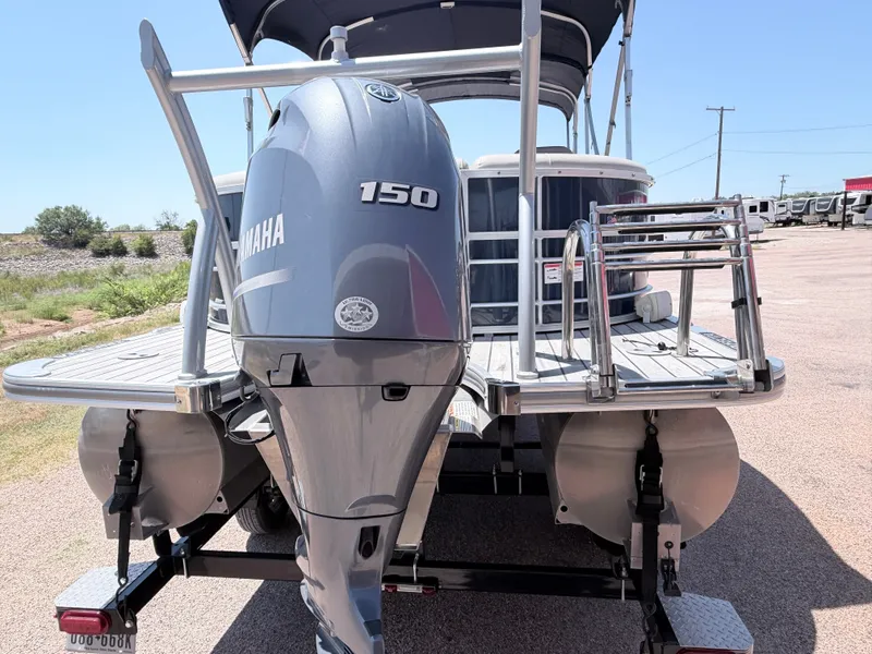 Slide: The Image of A 2018 Trifecta pontoon boat with a Yamaha 150 outboard motor, parked on a trailer. - 6
