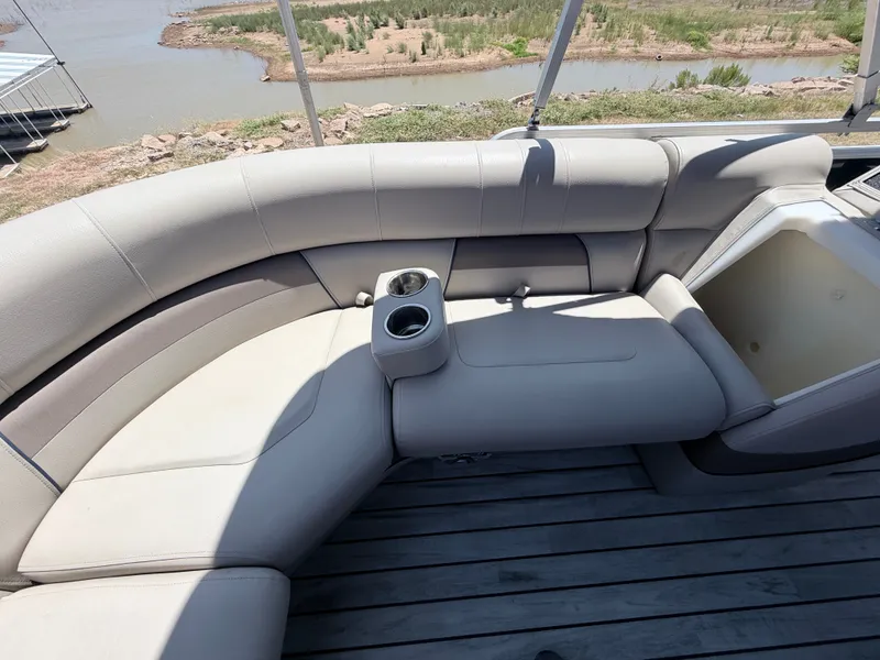 Slide: The Image of A sleek, cream-colored seating area on a boat with cup holders, surrounded by water and landscape. - 18