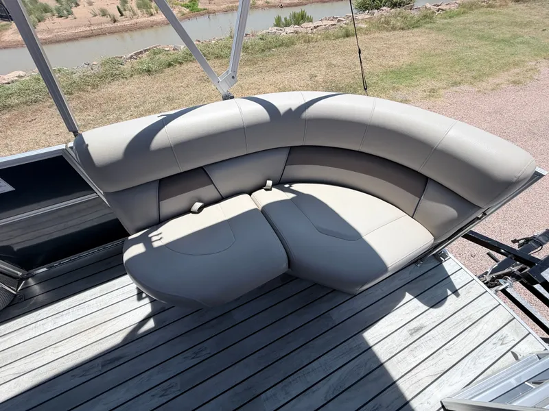 Slide: The Image of A sleek, cream-colored seating sofa on a boat with wooden flooring and railing. - 15