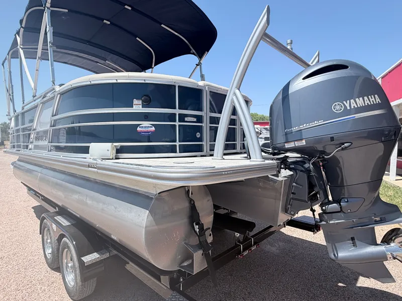 Slide: The Image of A 2018 Trifecta pontoon boat with a Yamaha outboard motor, parked on a trailer. - 5