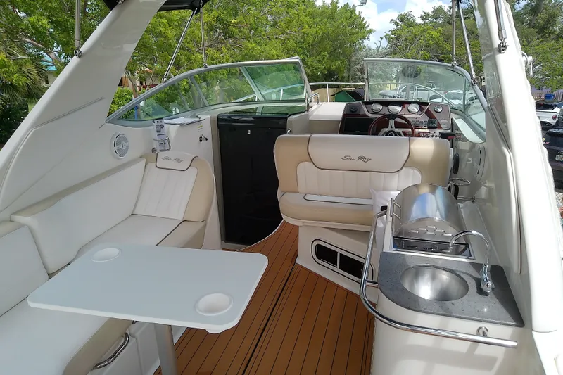 Slide: The Image of 2012 Sea Ray Sundancer 280 interior with seating, table, and kitchenette on deck. - 14
