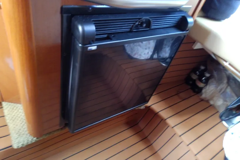 Slide: The Image of Interior of 2012 Sea Ray Sundancer 280 with compact refrigerator and wooden flooring. - 42