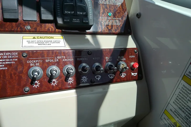 Slide: The Image of Control panel of a 2012 Sea Ray Sundancer 280 boat with various switches and caution labels. - 27