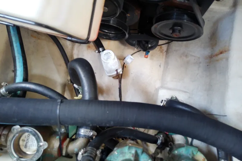 Slide: The Image of Engine compartment of a 2012 Sea Ray Sundancer 280 with visible hoses and components. - 56