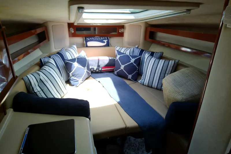 Slide: The Image of Interior of 2012 Sea Ray Sundancer 280 with cozy seating and nautical-themed pillows. - 36