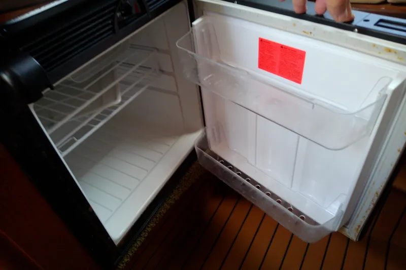 Slide: The Image of Open refrigerator inside a 2012 Sea Ray Sundancer 280 boat, showing empty shelves. - 43