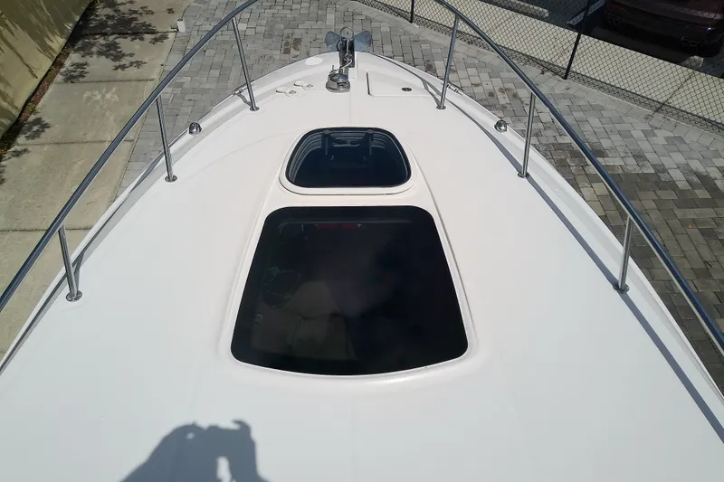 Slide: The Image of 2012 Sea Ray Sundancer 280 boat deck with hatches and railings, docked on paved surface. - 30