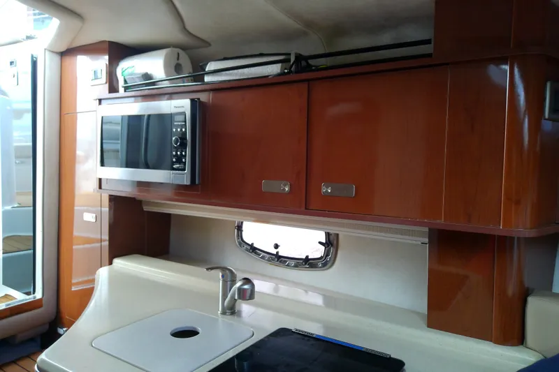Slide: The Image of Interior of 2012 Sea Ray Sundancer 280 yacht with kitchenette, microwave, and wooden cabinets. - 40