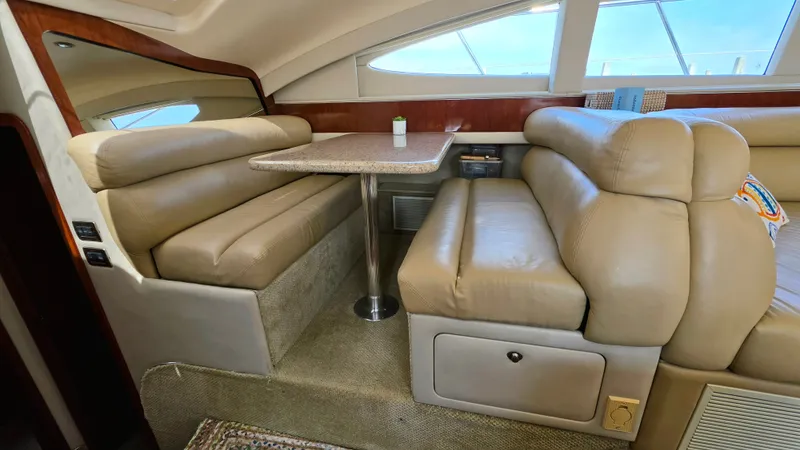 Slide: The Image of Interior of the 2004 Sea Ray 480 Motor Yacht with beige leather sofas and a table. - 26