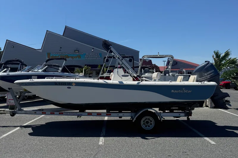 The Image of 2012 NauticStar 210 Coastal boat on trailer in parking lot, sunny day. - 1