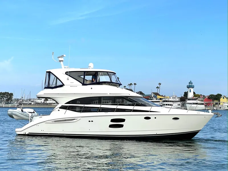 Slide: The Image of 2012 Meridian 441 Sedan yacht cruising near a coastal lighthouse. - 1