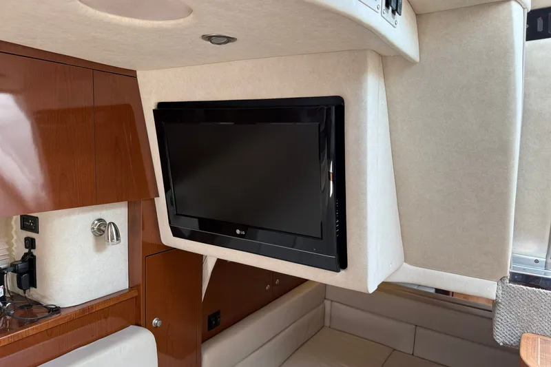 Slide: The Image of Interior of 2008 Sea Ray Sundancer 350 with mounted LG TV and wooden cabinetry. - 34