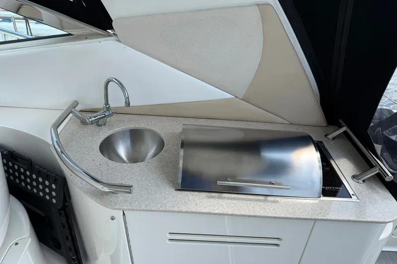 Slide: The Image of Compact kitchenette on 2008 Sea Ray Sundancer 350 yacht with sink and covered stove. - 12