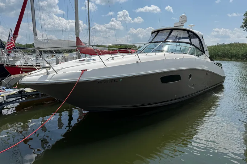 Slide: The Image of 2008 Sea Ray Sundancer 350 yacht docked in a marina under a sunny sky. - 1