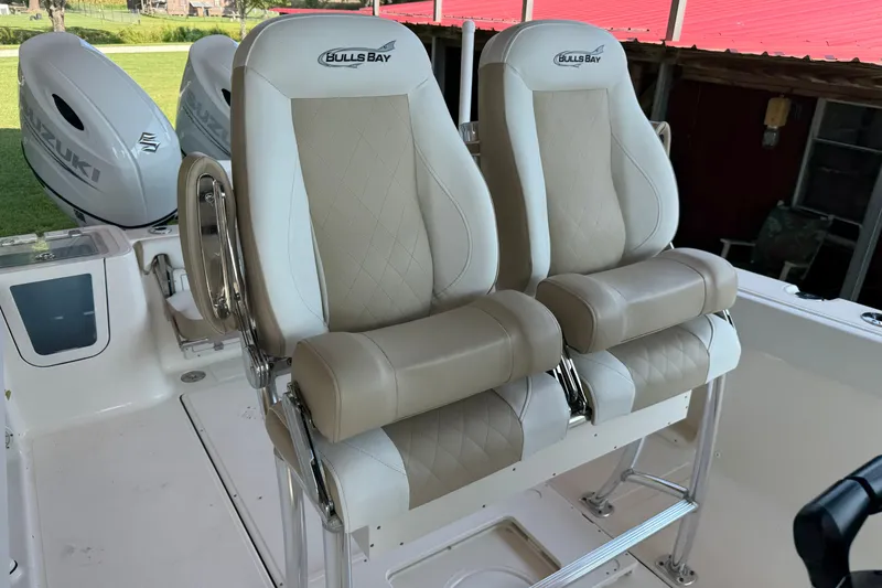 Slide: The Image of 2026 Bulls Bay 255 Center Console boat seats with Suzuki engines in background. - 23