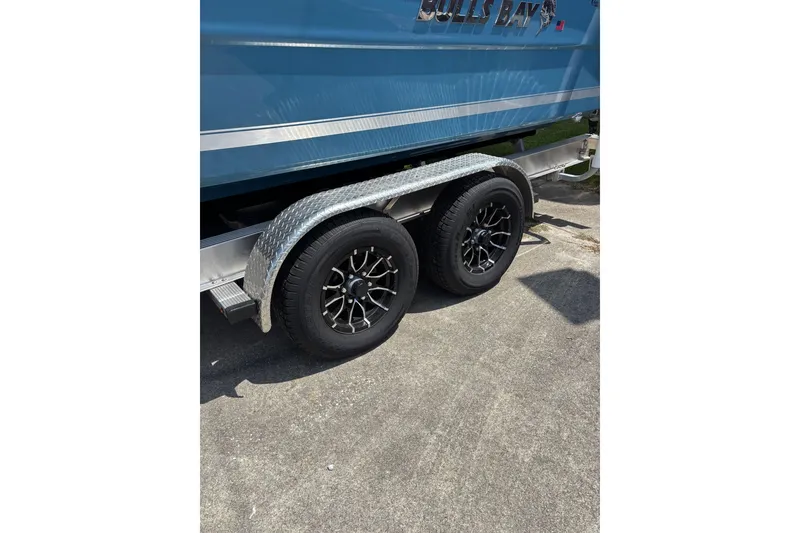Slide: The Image of 2026 Bulls Bay 255 Center Console boat on trailer with dual black wheels. - 7