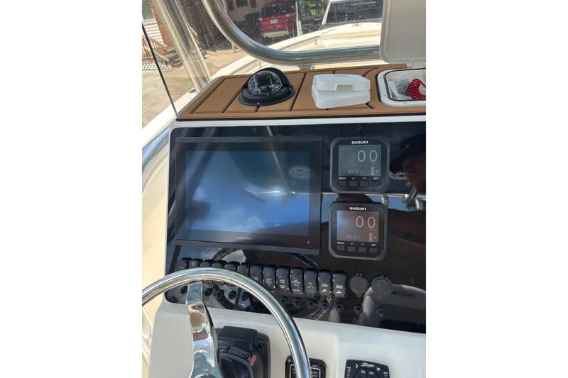 Slide: The Image of 2026 Bulls Bay 255 Center Console dashboard with Garmin display and Suzuki controls. - 13