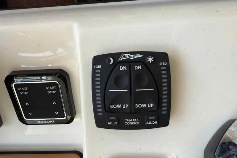 Slide: The Image of Bulls Bay 255 Center Console 2026 boat controls featuring Bennett trim tab and Suzuki start/stop panel. - 16