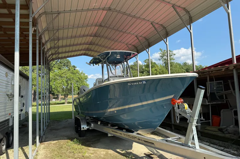 Slide: The Image of 2026 Bulls Bay 255 Center Console boat on trailer under metal canopy. - 4