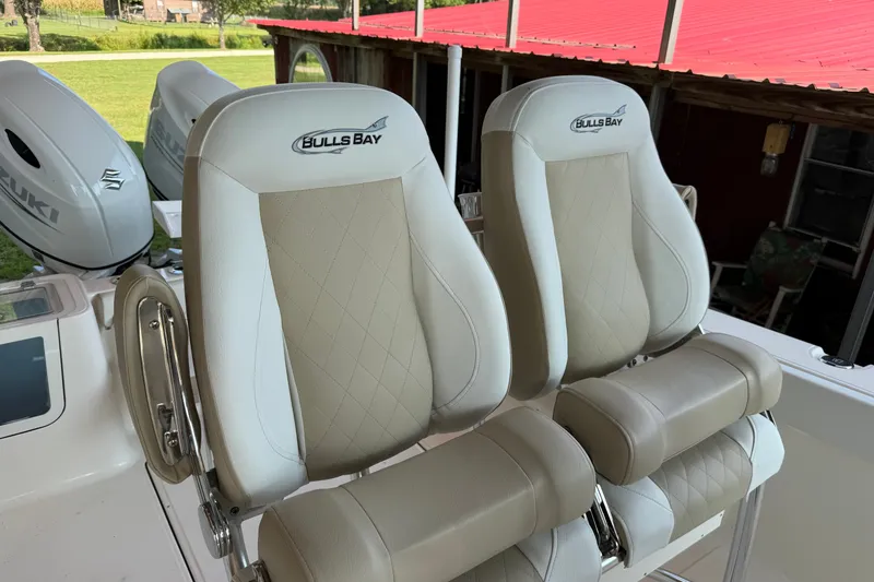 Slide: The Image of 2026 Bulls Bay 255 Center Console boat seats with Suzuki engines in background. - 10