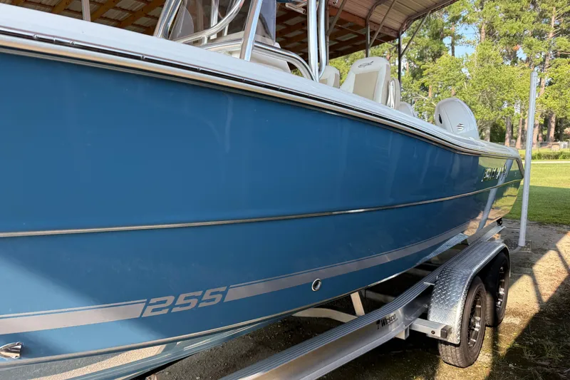 Slide: The Image of 2026 Bulls Bay 255 Center Console boat on trailer, blue hull, parked outdoors. - 5