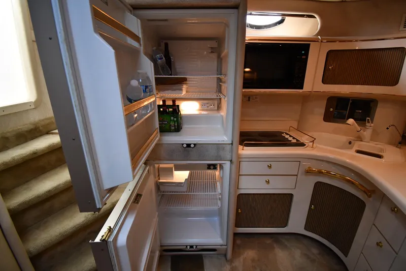 Slide: The Image of Interior of 1995 Sea Ray 630 Sundancer yacht kitchen with open fridge and modern amenities. - 58
