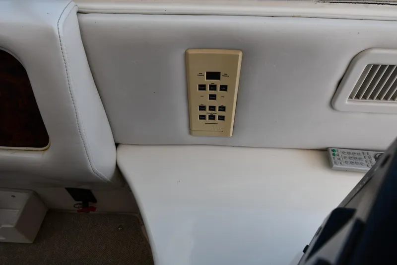 Slide: The Image of Control panel and remote on 1995 Sea Ray 630 Sundancer yacht interior. - 33