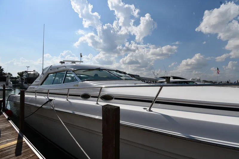 Slide: The Image of 1995 Sea Ray 630 Sundancer yacht docked under a partly cloudy sky. - 2