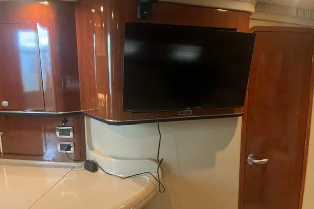 Slide: The Image of Interior of 2005 Sea Ray Sundancer 260 with mounted TV and wooden cabinetry. - 23